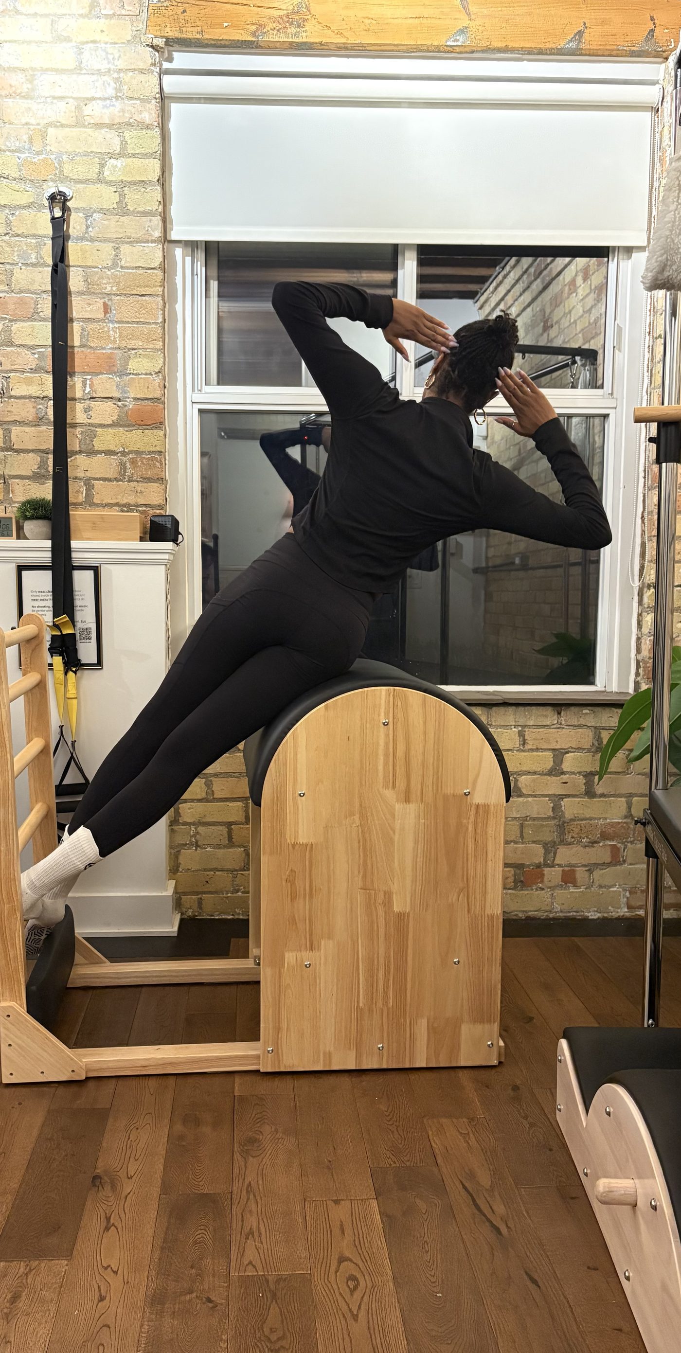 Ruqayyah stretching over the ladder barrel, spine in a long side bend